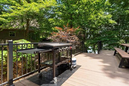 a grill on a deck with a bench and trees at Ambassador Ridge w/Optional Boat Rental in Sherrills Ford