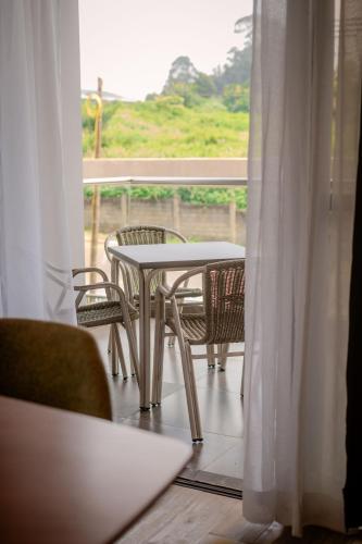 a table and chairs on a balcony with a window at Trademark Suites at Enaki Town in Nairobi