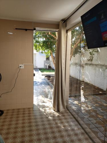 an empty room with a glass door and a tv at Pousada Monte Gerizim in Sao Paulo