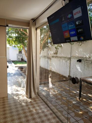 a sliding glass door with a tv on the wall at Pousada Monte Gerizim in Sao Paulo
