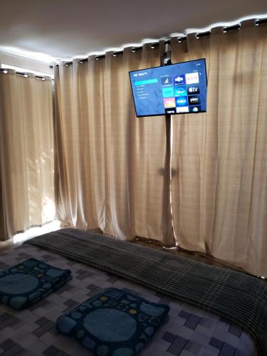 a room with curtains and a flat screen tv at Pousada Monte Gerizim in Sao Paulo