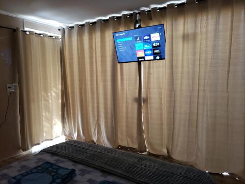 a bedroom with a tv and a bed with curtains at Pousada Monte Gerizim in Sao Paulo