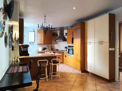 une cuisine avec des armoires en bois et une table et des chaises dans l'établissement Rue Faustin Helie - Paris 16, à Paris