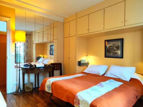 une chambre avec un grand lit et un bureau dans l'établissement Rue Faustin Helie - Paris 16, à Paris