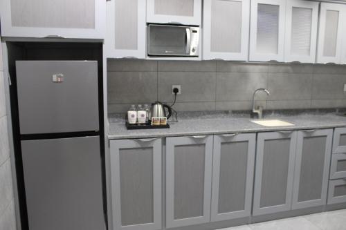 a kitchen with a refrigerator and a microwave at منتجع حياة ريزيدنس in Abha