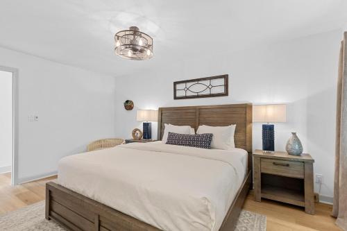 a bedroom with a large white bed and a table at Niblick on Norman w/Heated Pool & Optional Boat Rental in Cornelius