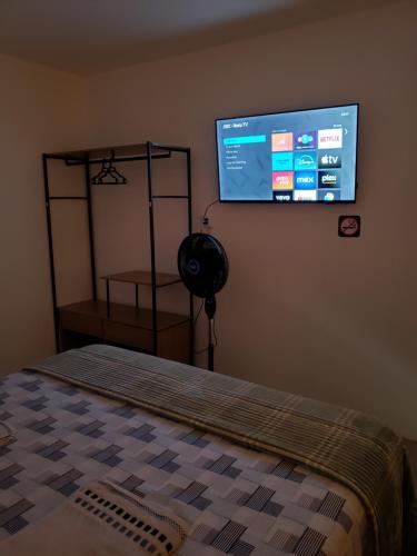 a bedroom with a bed and a tv on the wall at Pousada Monte Gerizim in Sao Paulo