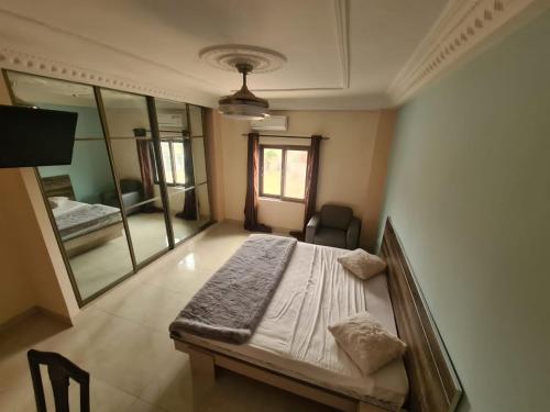 a bedroom with a bed and a large mirror at RÉSIDENCE TABARA Thies in Thiès