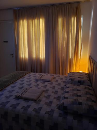 a bedroom with a bed and a window with curtains at Pousada Monte Gerizim in Sao Paulo