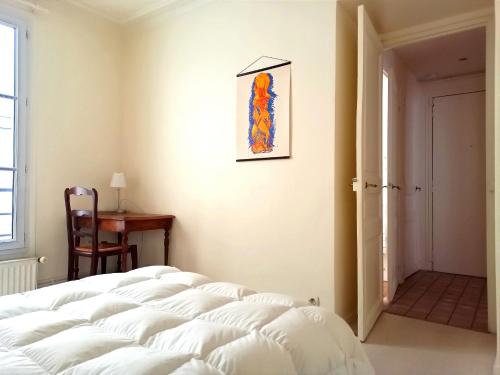 une chambre avec un grand lit blanc dans une pièce dans l'établissement Rue Poncelet - Paris 17, à Paris