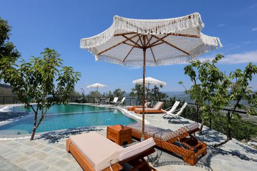 a pool with chairs and an umbrella next to a swimming pool at Sunrise House - Swimming Pool in Berat