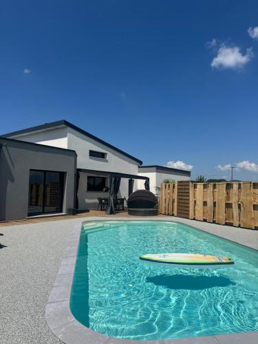 une piscine avec deux planches de surf devant une maison dans l'établissement Villa familiale le perrey, à Le Perrey
