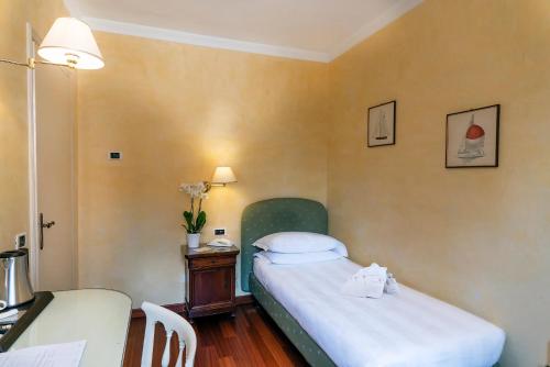 a small bedroom with a bed and a desk at Phi Hotel Canalgrande in Modena