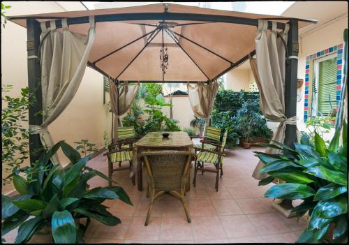eine Terrasse mit einem Tisch, Stühlen und einem Sonnenschirm in der Unterkunft B&B Livingstone in Cagliari