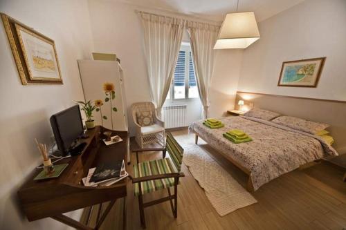 Schlafzimmer mit einem Bett und einem Schreibtisch mit einem Computer in der Unterkunft B&B Livingstone in Cagliari