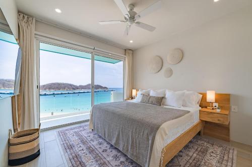 une chambre avec un lit et une grande fenêtre dans l'établissement 3044 - Playa Sur Santa Cruz 301, à Santa Cruz Huatulco