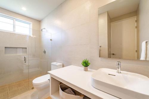 une salle de bain avec un lavabo, des toilettes et un miroir dans l'établissement 3044 - Playa Sur Santa Cruz 301, à Santa Cruz Huatulco