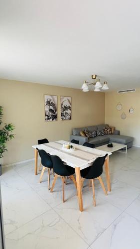 un salon avec une table, des chaises et un canapé dans l'établissement Super logement - Mer à 5 min à pieds !, à Nice