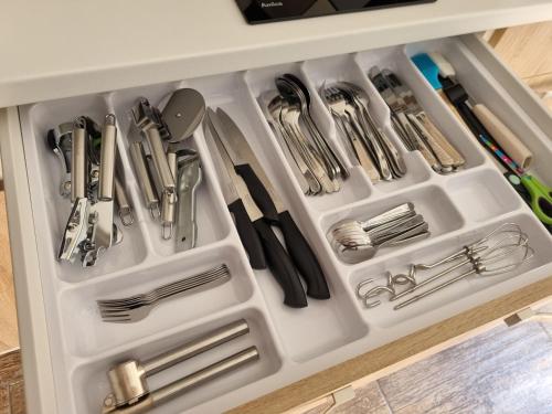 a white drawer filled with utensils in a kitchen at Apartmány 235 - 1 in Jaroměř