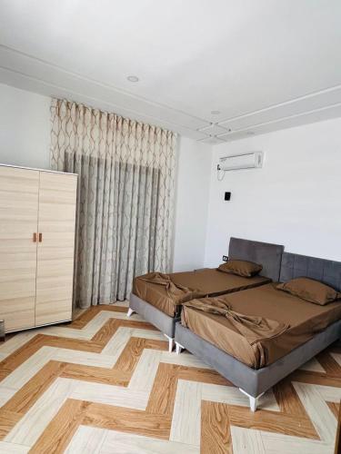 a bedroom with a bed and a wooden floor at Villa Géant in Awlād ‘Umar