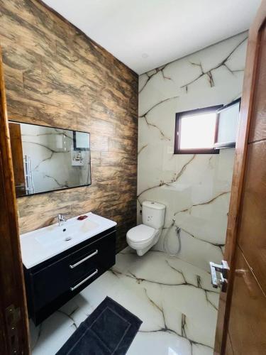 a bathroom with a sink and a toilet and a mirror at Villa Géant in Awlād ‘Umar