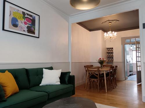 un salon avec un canapé vert et une table dans l'établissement Maison familiale centre-ville 4 chambres mezzanine, à Saint-Brieuc