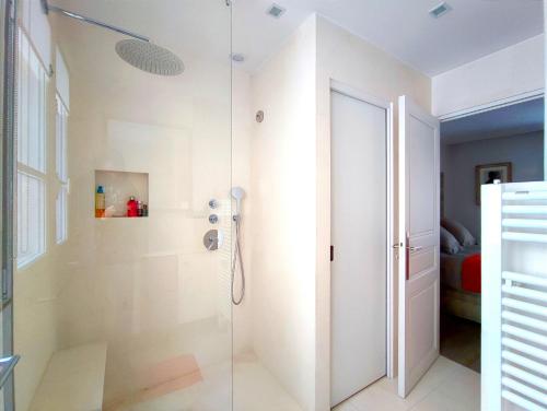 une salle de bain avec une douche avec une porte vitrée dans l'établissement Rue de l'Université - Paris 7, à Paris