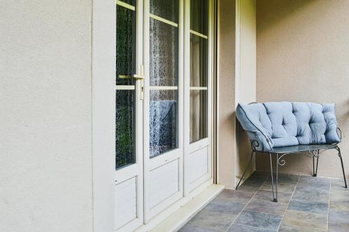 ein blauer Stuhl neben einer Tür in der Unterkunft Beautiful Cottage Disneyland Paris - Rentaway BnB in Chessy