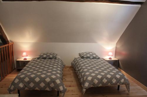 MosnesにあるGîte de La Huaudièreのベッド2台、ランプ2つ(テーブル付)が備わる客室です。