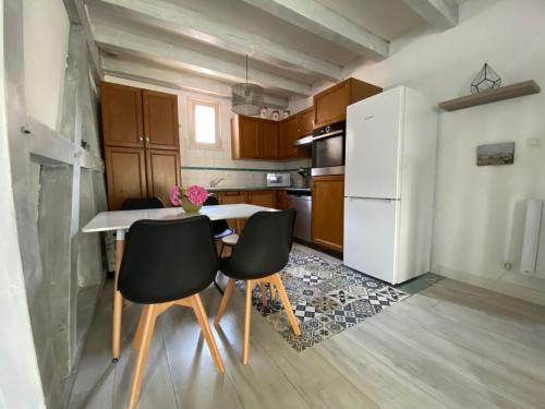 a kitchen with a table and chairs and a refrigerator at Relais du Dompeter in Molsheim