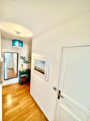 Cette chambre dispose d'une porte blanche et de parquet. dans l'établissement L'Escapade Deauvillaise, T2 en plein coeur de la ville, à Deauville