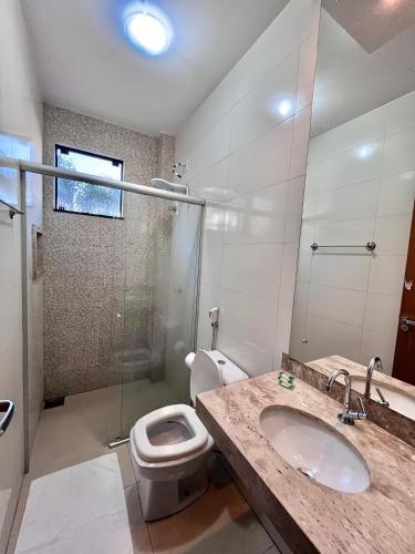 a bathroom with a toilet and a sink and a shower at Veneza Plaza Hotel in Gurupi