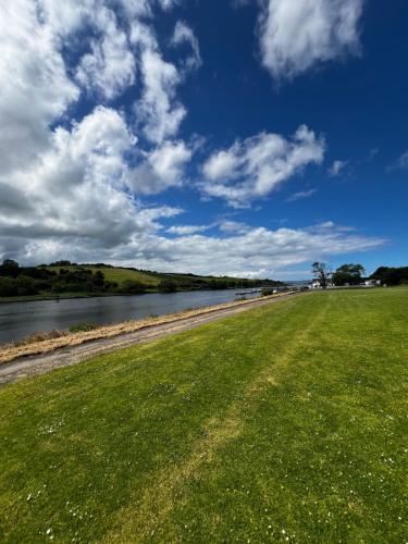 a grassy field next to a body of water at The Cranagh in Coleraine