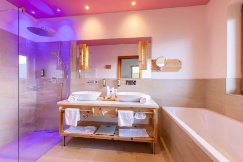 a bathroom with a tub and a sink and a tub and shower at Natur- und Wellnesshotel Höflehner in Haus im Ennstal