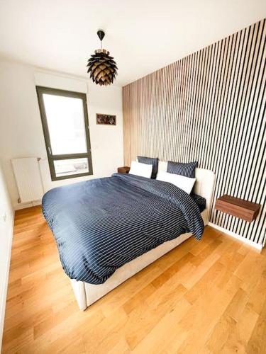 a bedroom with a large bed with a blue blanket at Penthouse with rooftop in Colombes