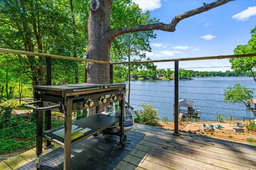 a grill on a deck with a tree and water at Nancy Key w/Pool, Wine Cave, Optional Boat Rental in Denver