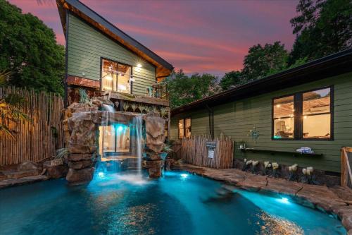 a pool with a waterfall in front of a house at Nancy Key w/Pool, Wine Cave, Optional Boat Rental in Denver