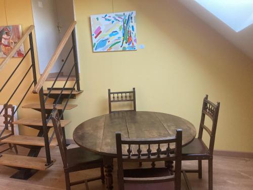 une table de salle à manger avec des chaises et un tableau au mur dans l'établissement Chez Anne - Chambre avec salle de bain privative, à Menetou-Couture
