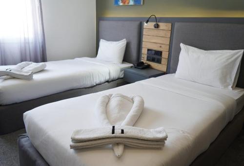 a hotel room with two beds with towels on them at Aitch Boutique Hotel - an LIH Hotel in Madaba