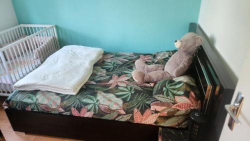 Ein ausgestopfter Teddybär sitzt auf einem Bett in der Unterkunft Sogo in Villeneuve-sur-Lot