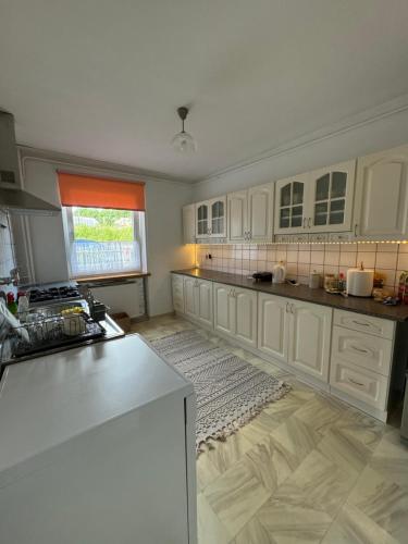 a kitchen with white cabinets and a white counter top at Pensjonat Monika in Mikołajki