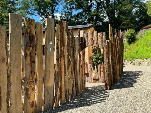 a fence of logs on the side of a road at Domaine des Constellations - Tiny Houses & Bains Nordiques in Orbey