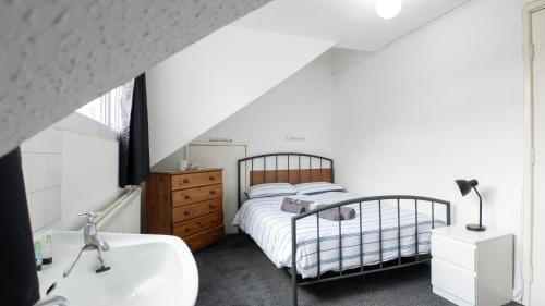 a bedroom with a bed and a sink and a tub at Pebbles guest house room 8 in Southampton