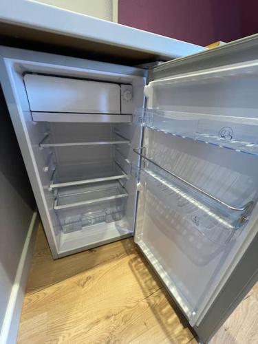 un réfrigérateur vide avec une porte ouverte dans une pièce dans l'établissement Appartement avec Sauna - Europa Park, à Benfeld