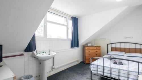 a bedroom with a sink and a bed and a window at Pebbles guest house room 8 in Southampton