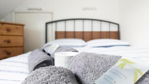 a bed with towels and a cup on it at Pebbles guest house room 8 in Southampton