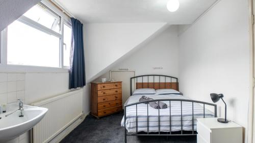 a bedroom with a bed and a sink and a window at Pebbles guest house room 8 in Southampton