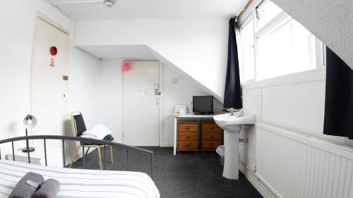 a bedroom with a bed and a sink and a window at Pebbles guest house room 8 in Southampton