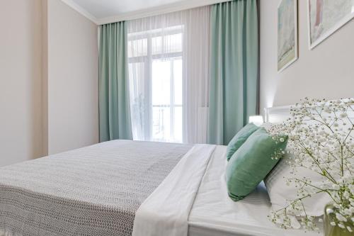 a bedroom with a bed with green curtains and a window at Tokyo, a Residential Complex in Astana