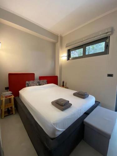 a bedroom with a bed with two towels on it at Beachfront Retreat at Agios Vasileios in Patra